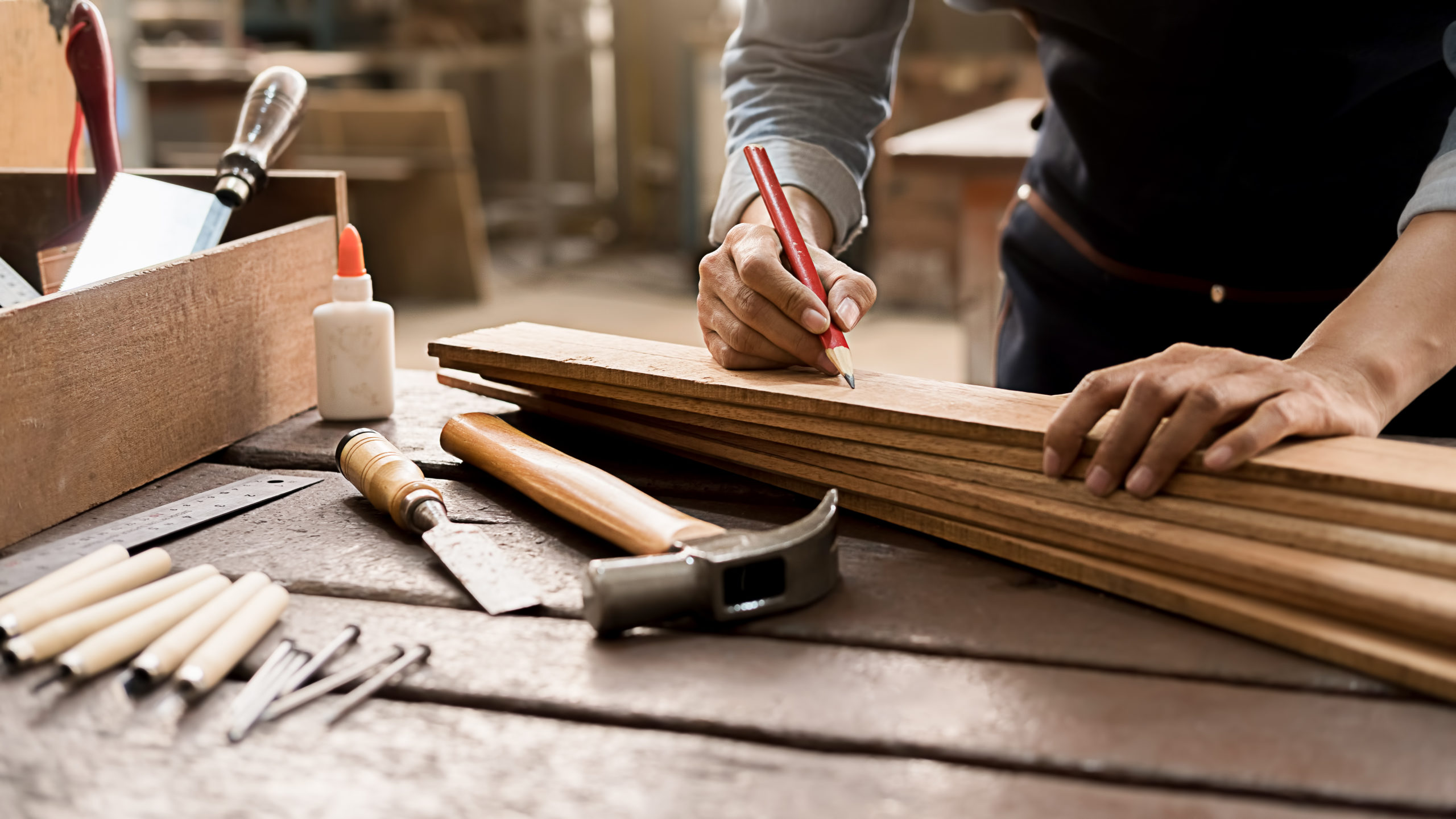 Carpenter working with equipment on wooden table in carpentry shop. woman works in a carpentry shop.
